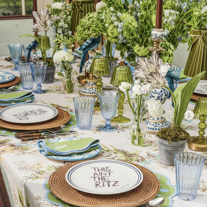 Elegant table setting with floral arrangements, colorful glasses, and decorative plates.