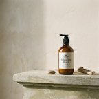 Brown bottle labeled 'Whitstable Beach' on a stone surface with a neutral background